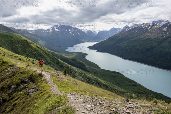 Climbers on a hiking trail, view of blue lake and mountains on Twin Peaks Trail, Eklutna Lake,