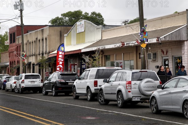 Bustling main street in Mamou with parked cars and buildings, Mamou, Louisiana, USA