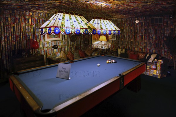 Billiard room with blue table and bright strip lights, cozy atmosphere in Graceland, Memphis,