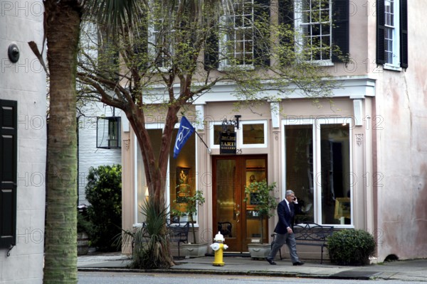 Elegant building with large windows and trees in front of it on a street in Charleston, Charleston,
