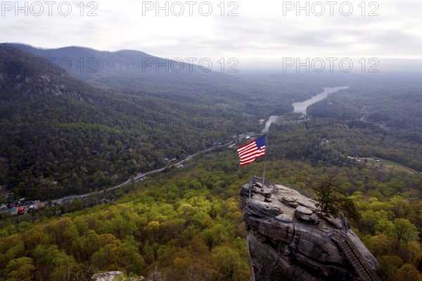 Majestic view of Chimney Rock with US flag and vast forests, zero
