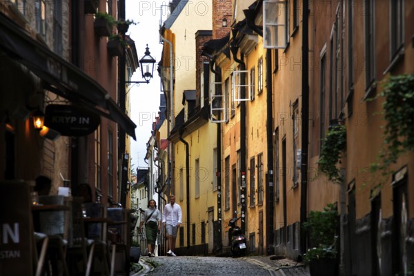 A lively old town alleyway in Stockholm, surrounded by colorful buildings and historic charm,