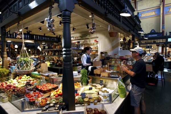 Lively market hall in Östermalm with a variety of food stalls and hustle and bustle, Stockholm,