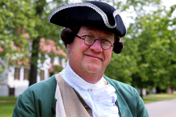 Man in authentic colonial clothing smiling relaxed at camera, friendly portrait, Williamsburg,