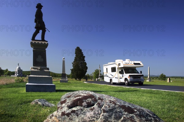 A memorial stands in front of a motorhome in an open, green area of Gettysburg National Military