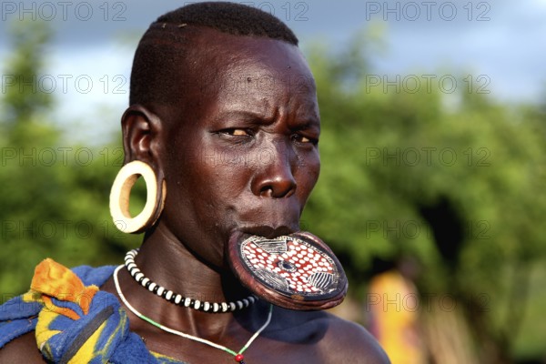 Close-up of a Mursi woman with lip plate in Mago National Park. She is wearing traditional