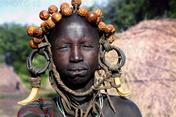 Woman wearing eye-catching headdress and traditional clothing in Mago National Park, Mago National
