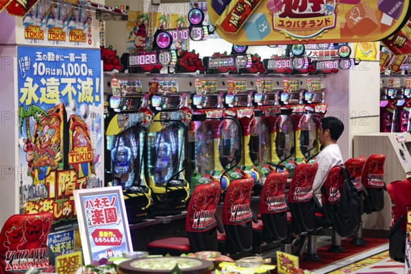 Colorful pachinko play area in Shibuya with advertising banners, Tokyo, Japan