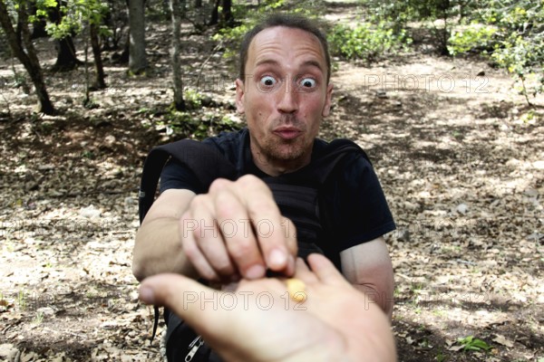 Man feeding enthusiastically from hand in the forest, Azrou, Forèt des Cèdres, Morocco