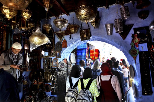Bustling souk in the medina of Chefchaouen surrounded by blue walls and lights, Chefchaouen,