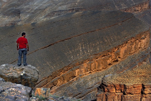Man standing on rocks and looking at the impressive Dadès Gorge, Dadès, Morocco
