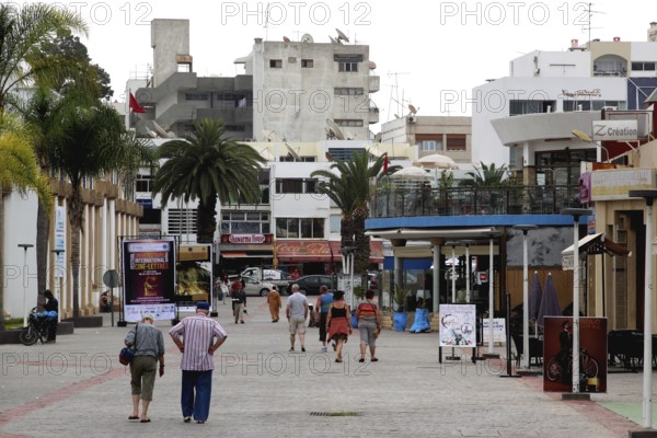 Passers-by stroll through Agadir's pedestrian zone under palm trees, Agadir, Souss, Morocco