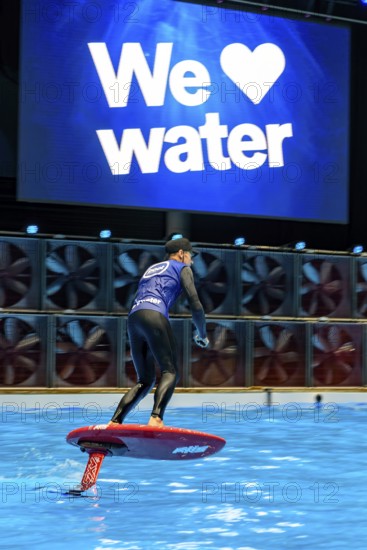 Press photo dynamic photo of eFoil surfer in the large XXL pool in Hall 17 of Messe Boot