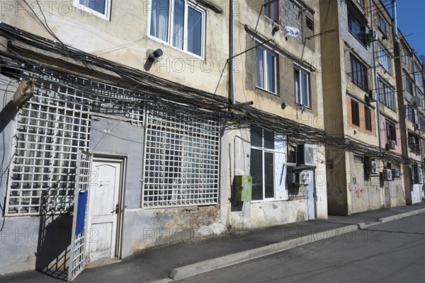Multi-storey apartment block with lots of exposed cables and aged façade, Gori, Inner Kartli