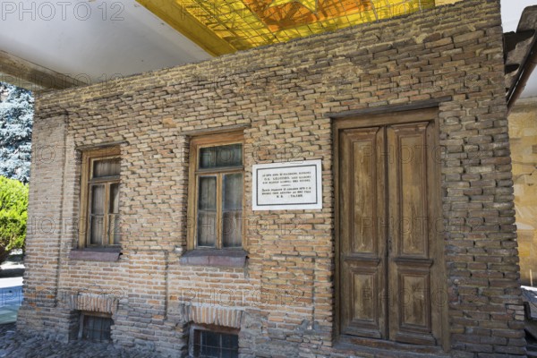 Brick wall of a building with wooden doors and windows, rustic appearance, birthplace of Josef