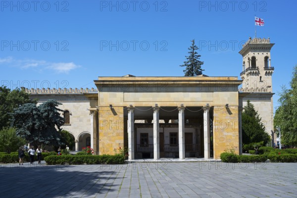 Historic building with columns and Georgian flag in clear blue sky, Josef Stalin Museum, Gori,