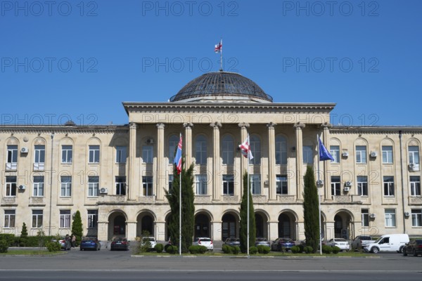 View of classic building with dome and flags surrounded by cypresses, City Hall, Gori, Inner Kartli