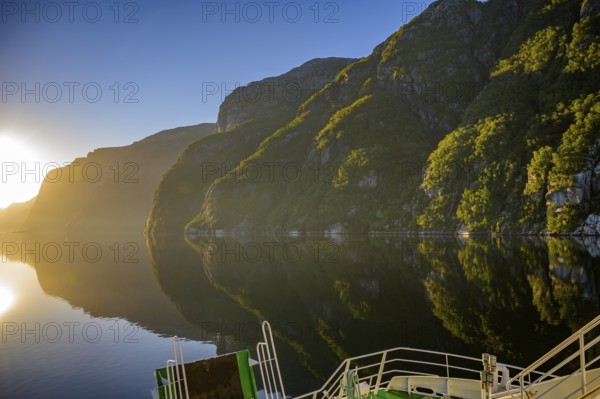 Tranquil fjord shore of Lyseford, illuminated by soft evening light with reflecting waters and dark