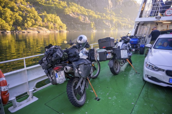 Motorbikes with luggage on a Kolumbsu shipping company ferry on the Lysefjord in sunny weather,