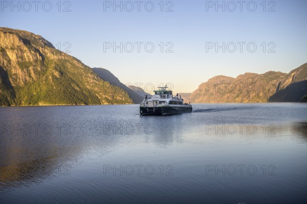 Columbus shipping company ferry moves through the Lysefjord with mountains in the background in the