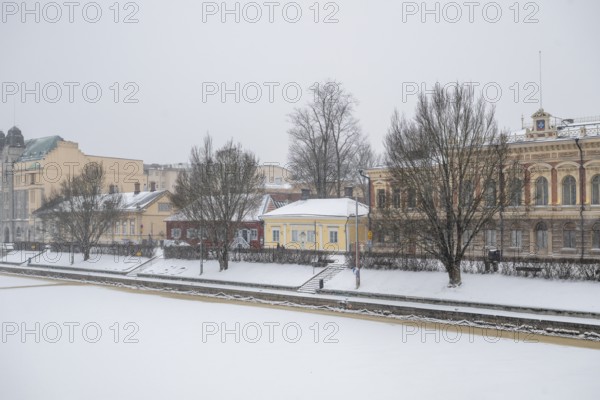 Pharmacy museum and other historic buildings on the frozen Aurajoki river, wintery Turku or Swedish