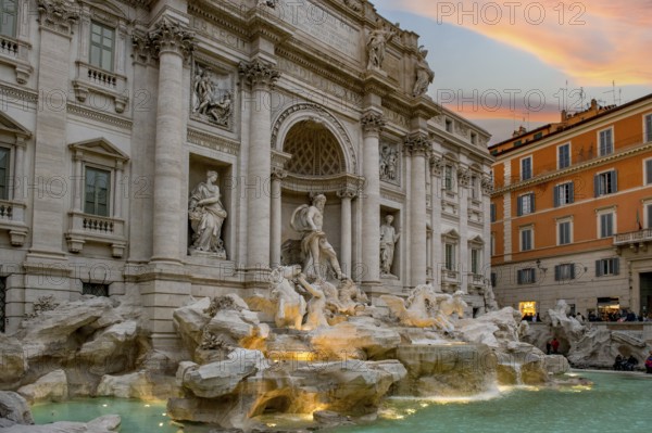 View at dusk at dusk with dramatic light in the sky of the partially illuminated Fontana di Trevi