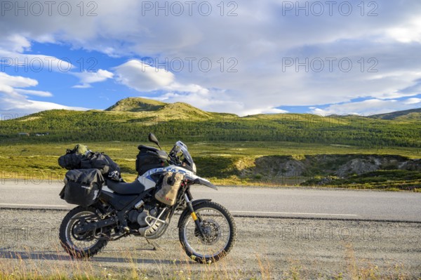 Dalholen, Innlandet, Norway, BMW G 650 GS Sertao enduro motorcycle along a road through green hills