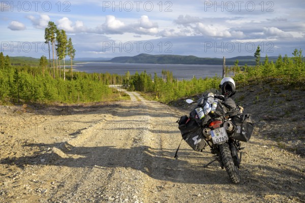 Lövdalen, Jämtland County, Sweden, A dirt road leads through slightly wooded terrain with a BMW G
