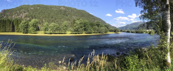 Sand, Rogaland Municipality, Norway, Clear river surrounded by green trees and meadows under a blue
