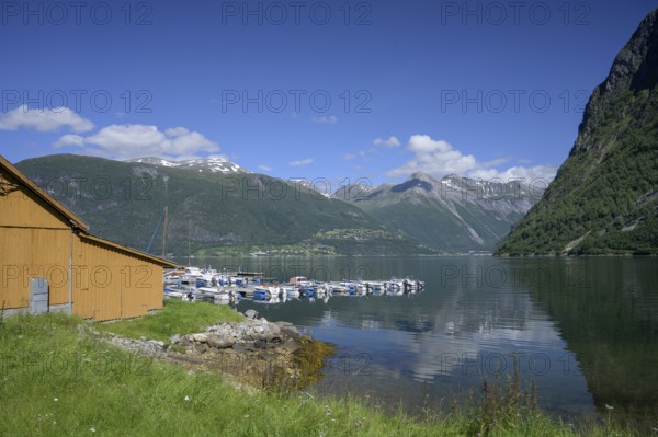 Norddal, Møre og Romsdal province, Norway, wooden cabin on the shore of a fjord with boats and