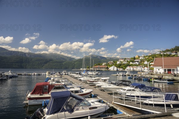 Sand, Rogaland Municipality, Norway, boats in harbor on a sunny day with mountains in the