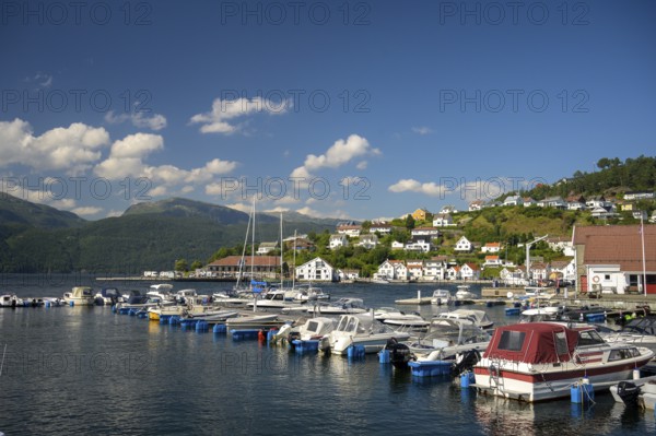 Sand, Rogaland municipality, Norway, boats in the harbor in front of a city with mountains and blue