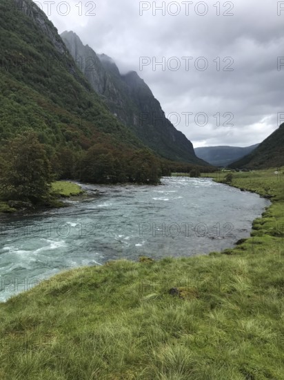 Byrkjelo, Vestland, Norway, river flows through a valley surrounded by green meadows and thick