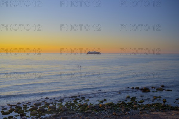 Hirtshals, Nordjylland region, Denmark, sunset over a calm sea with gentle waves and rocks on the