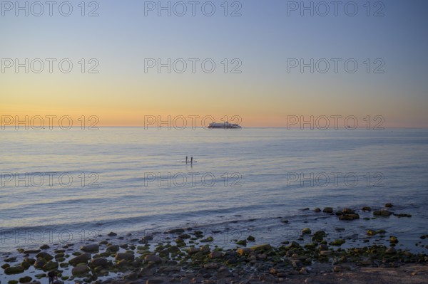 Hirtshals, Nordjylland region, Denmark, sunset over a calm sea with gentle waves and rocks on the