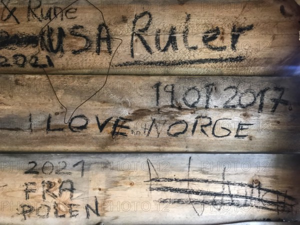 Drevsjø, Innlandet, Norway, wooden wall with graffiti and inscriptions, including countries and
