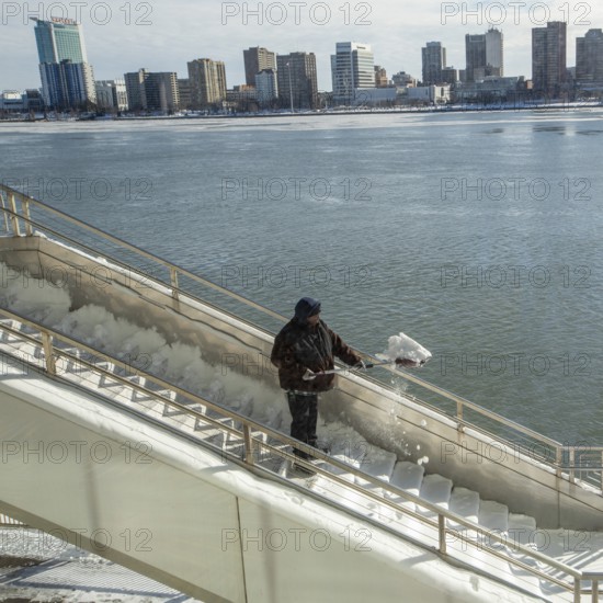 Detroit, Michigan USA - 15 January 2026 - A worker shovels snow from steps leading to Huntington