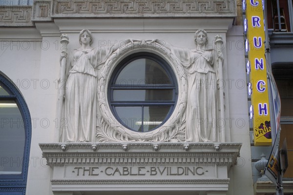 Two female sculptures above the entrance to the historic Cable Building, built in 1894 in Beaux