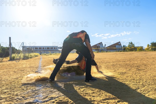 Two baseball players in action on a dirt field, with one player sliding headfirst into a base,