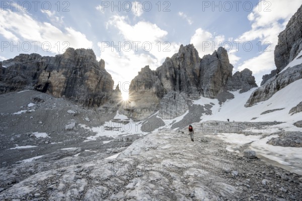 Ascent in a rocky mountain landscape with steep rocky peaks to Bocca degli Armi, Sun Star, Brenta