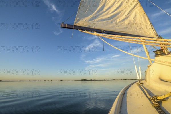 Sailing boat dinghy cruiser on calm Dümmer See, wide horizon, clear blue sky tint, Dümmer nature