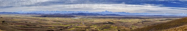 Extensive panorama with mountains and fields under cloudy sky, The Altiplano landscape in the Andes