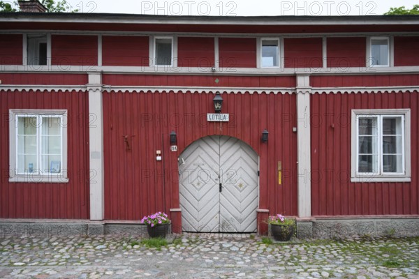 Street scene in the old town of Naantali, red historic wooden building with decorative windows on a
