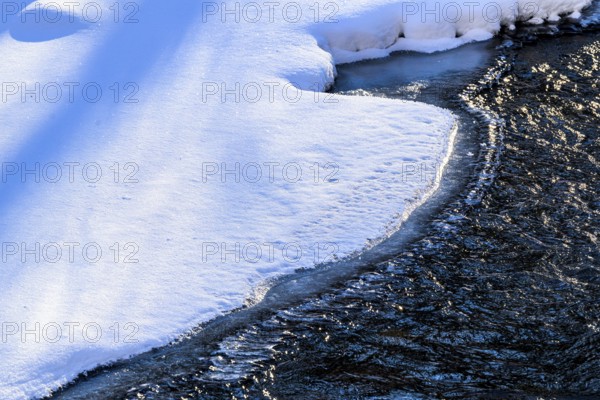 Ilsenburg, Saxony-Anhalt, Germany, A partially frozen Ilse river in the Harz National Park on