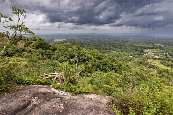 Far-reaching view of green forests and valleys under a dramatic cloudy sky, The landscape in the