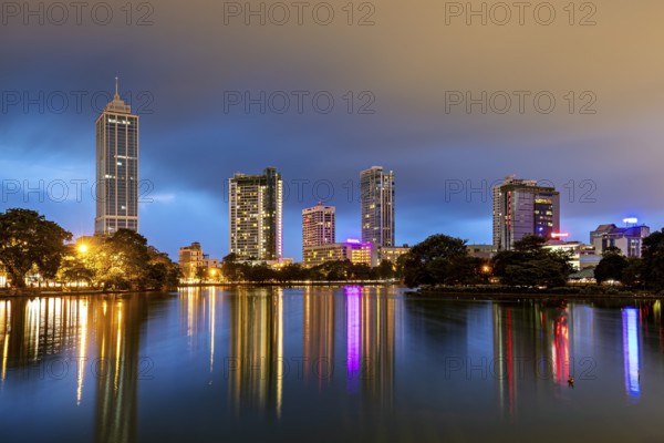 Nighttime cityscape with illuminated skyscrapers and reflections in the lake, the skyline of