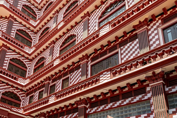 Detailed view of a red building façade with symmetrical window and pattern design, the old town