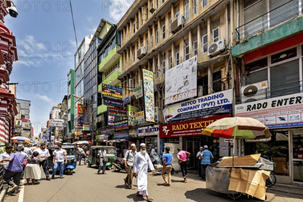 Busy shopping street with lots of people and colorful signs in sunny weather, In the streets of the