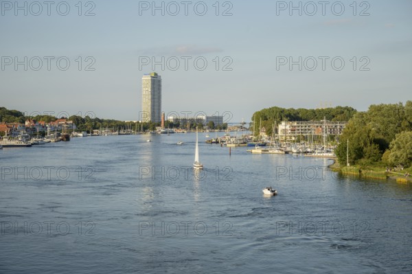 The river Trave crosses the city with a high-rise building and boats just in front of it flows into