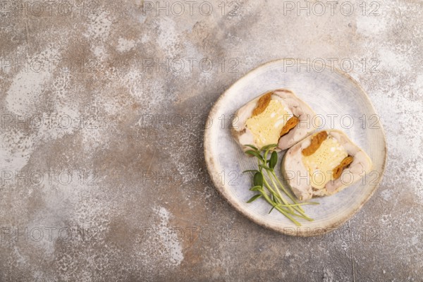 Chicken, egg and dried apricot meatloaf, microgreen on brown concrete background. top view, flat